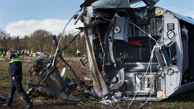 Emergency services look for evidence at the wreck of commuter train which derailed near Dalfsen Netherlands Tuesday Feb. 23 2016. The train derailed after slamming into a crane which was crossing the tracks early Tuesday in the eastern Netherlands