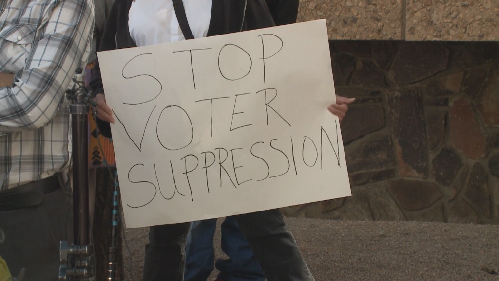 A protester holds up a sign outside the Arizona Capitol