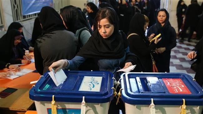 A voter casts her ballot at a polling station in Tehran