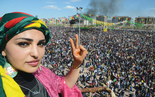 A woman makes the V-sign as Turkish Kurds gather as part of Nowruz celebrations in Diyarbakir on Monday