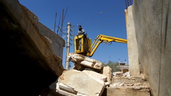 A worker fixes damaged electricity cables in the rebel held al Ghariyah al-Gharbiyah town in Deraa province