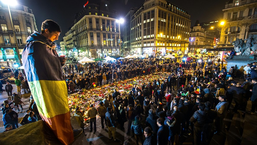 AFP  Getty Images              A man wrapped in a Belgian flag holds a candle at a memorial in front of Brussels’ Stock Exchange on Thursday