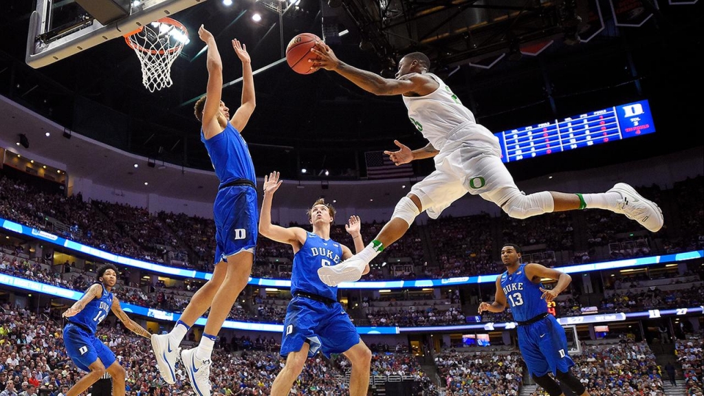 Oregons Elgin Cook passes the ball as Duke forward Chase Jeter defends