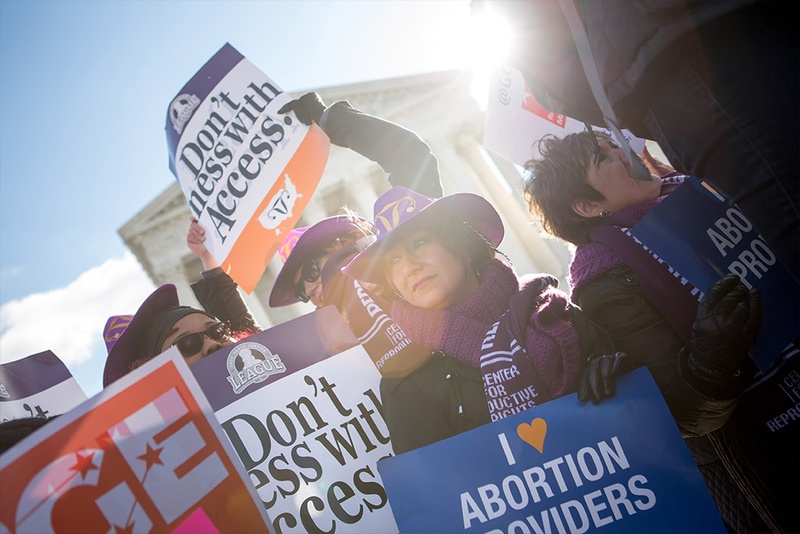 Lara Chelian center and her mother Renee Chilean both abortion providers from Michigan hold signs in front of the U.S. Supreme Court on Capitol Hill in Washington D.C. as Whole Woman’s Health v. Hellerstedt is argued inside Mar. 2 2016. The case