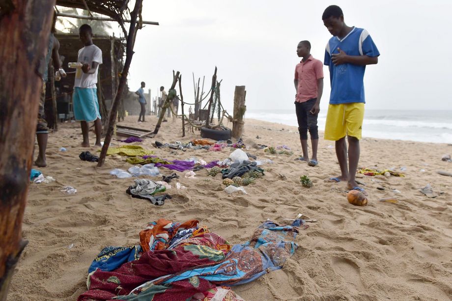 Residents look at items left on the beach a day after the terrorist attack in Grand-Bassam. Al Qaeda in the Islamic Maghreb claimed responsibility for the attack that killed 18 people