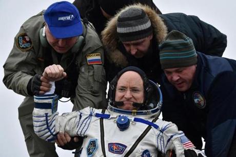 Ground personnel helped International Space Station crew member Scott Kelly off the space capsule that brought him home Wednesday