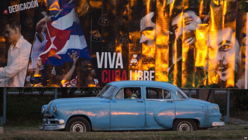 A taxi driving a classic American car passes a billboard that reads in Spanish'Long live free Cuba in Havana Cuba Monday