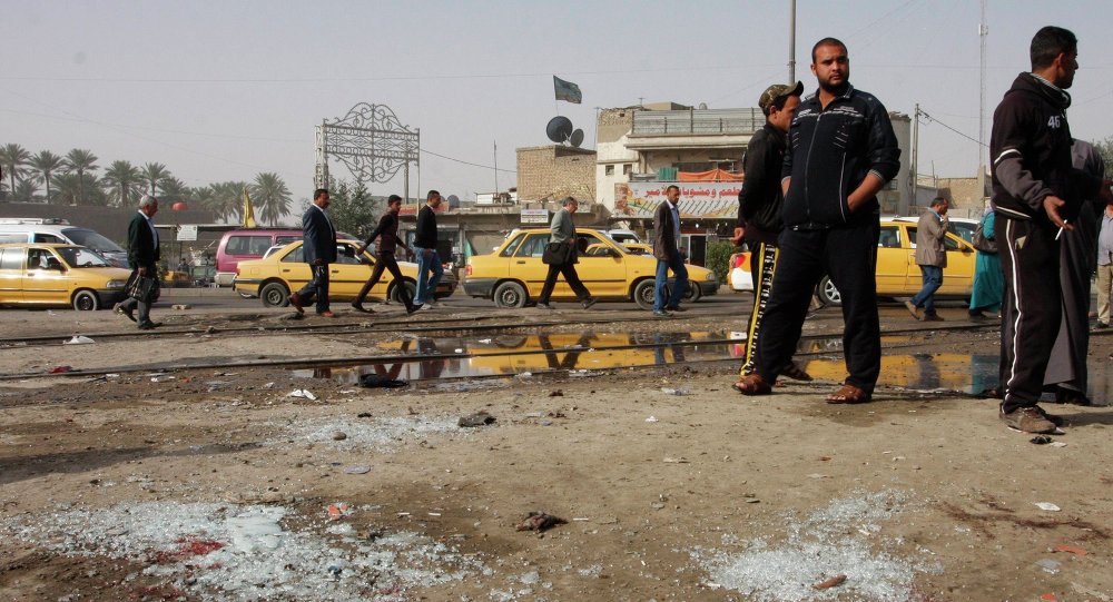 People gather at the site of a suicide bombing attack in the Shi'ite neighborhood of Kadhimiya in Baghdad