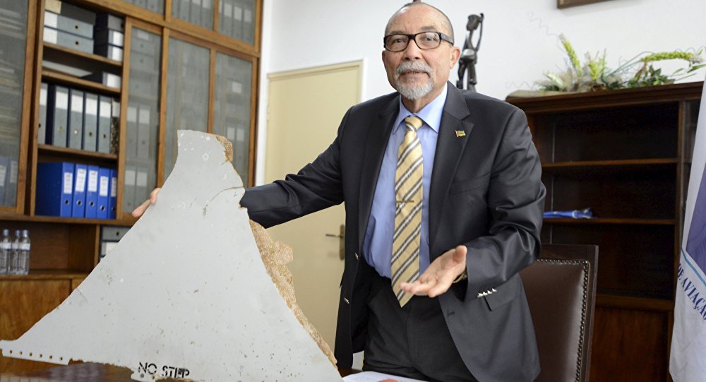 The head of Mozambique's Civil Aviation Institute Comandante Joao Abreu shows a piece of debris found on a beach that could be from a missing Malaysia Airlines flight MH370 in Maputo