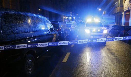 Police guard a check point during a police raid in the suburb of Schaerbeek in Brussels Friday March 25 2016. Belgium's prime minister refused to accept the resignations of his justice and interior ministers Thursday despite increasing evidence