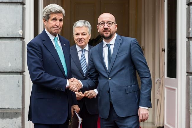 Belgium's Prime Minister Charles Michel right and Foreign Minister Didier Reynders center welcome U.S. Secretary of State John Kerry upon his arrival at the Prime Minister's residence in Brussels Belgium Friday