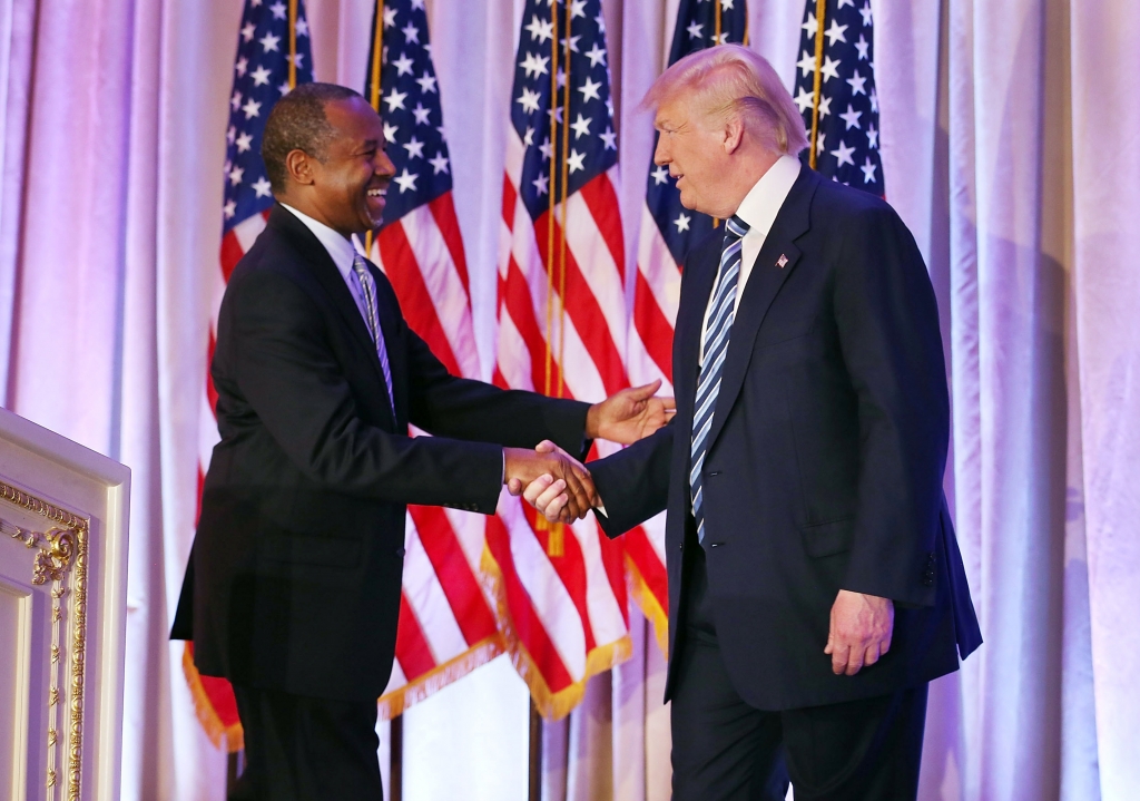 Republican presidential candidate Donald Trump shakes hands with former presidential candidate Ben Carson as he receives his endorsement at the Mar-A-Lago Club