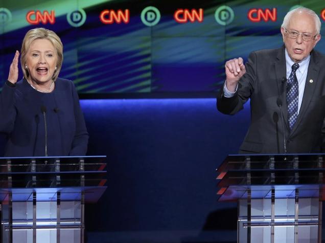 Democratic US presidential candidate Hillary Clinton and rival Bernie Sanders speak simultaneously during the Democratic US presidential candidates debate in Flint Michigan