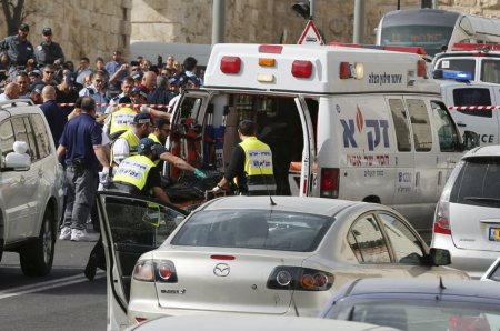 Israeli emergency personnel evacuate the body of one of the two Palestinian assailants whom police said carried out a drive-by shooting on a commuter bus in an east Jerusalem suburb before being shot dead by police opposite the Notre Dame Center just outs