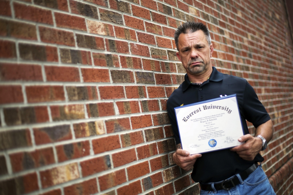 Shane Satterfield a roofer who owes more than $30,000 in debt for an associate's degree in computer science from one of the country's largest for-profit college companies that failed in 2014 holds his diploma in Atlanta.'I graduated in April