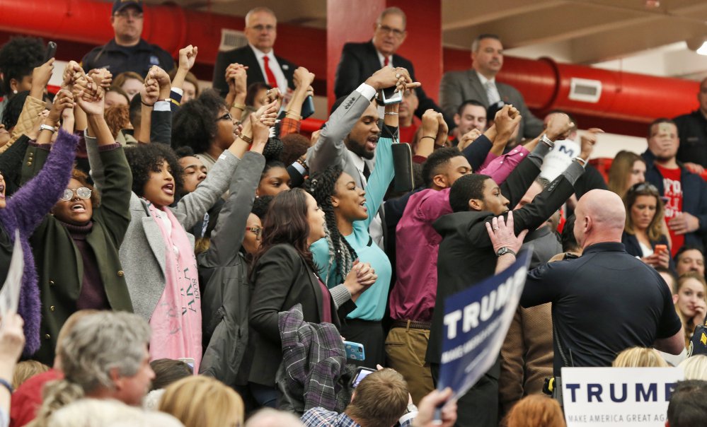 Protesters yell as they are escorted out of a rally for Republican presidential candidate Donald Trump at Radford University in Radford Va. Monday