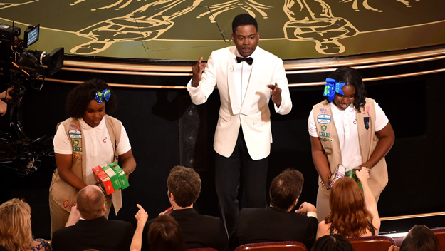 Host Chris Rock and Girl Scouts sell cookies to audience members during onstage during the 88th Annual Academy Awards at the Dolby Theatre