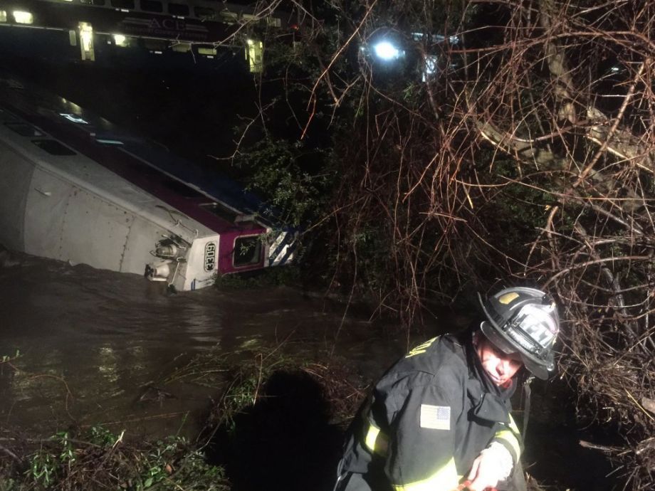 In this image provided the Alameda County Fire Department first responders work the scene after a car of a commuter train plunged into Alameda Creek after the train derailed Monday