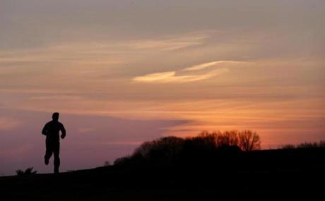 A jogger was silhouetted against the sunrise in Pope John Paul II Park in Dorchester Tuesday morning