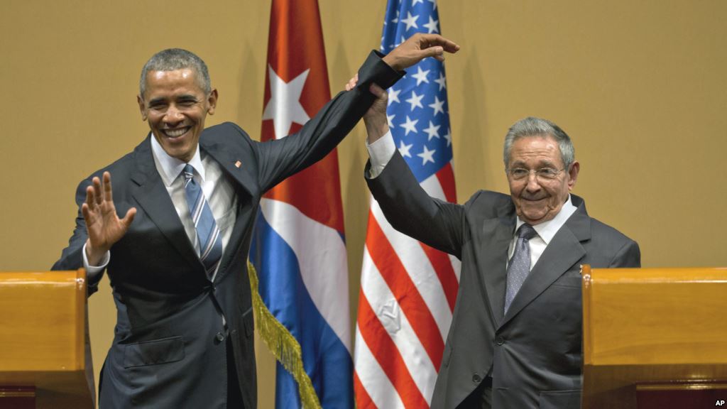 Cuban President Raul Castro right lifts up the arm of President Barack Obama at the conclusion of their joint news conference at the Palace of the Revolution Monday