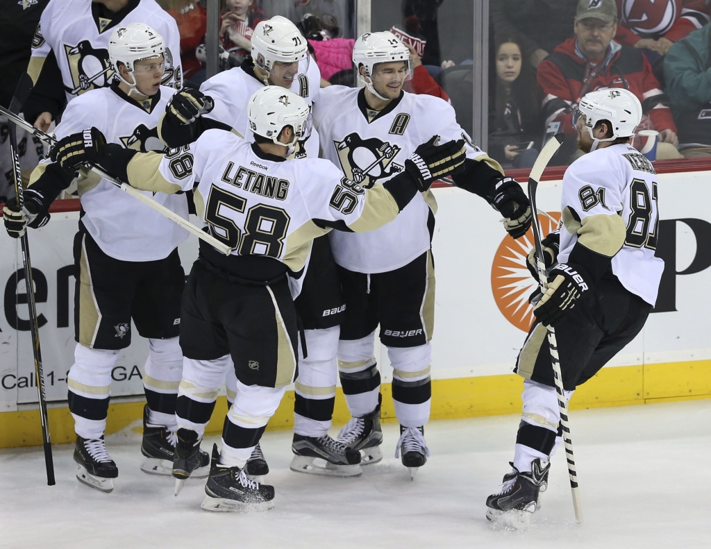 Penguins Devils Hockey-2 Penguins players celebrate a goal by center Evgeni Malkin during the second period against the New Jersey Devils Sunday in Newark N.J