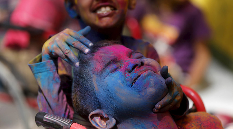 Disabled children cover each other in colored powder during Holi celebrations in Mumbai India