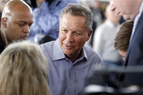 Republican presidential candidate Ohio Gov. John Kasich meets with attendees during a campaign stop on Monday