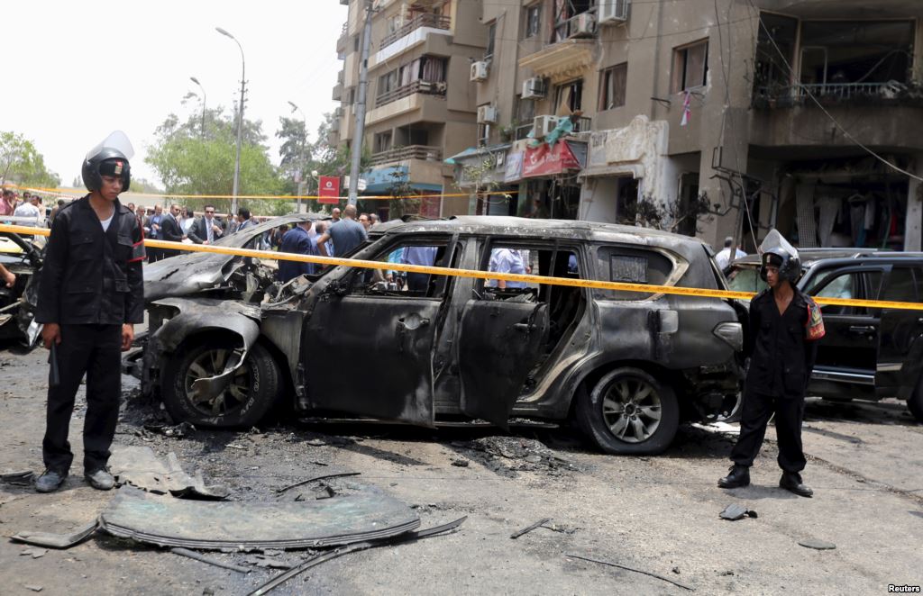 Policemen secure the site of a car bomb attack on the convoy of Egyptian public prosecutor Hisham Barakat near his house at Heliopolis district in Cairo