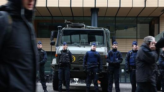 People walk past police officers as they exit Brussels Midi train station