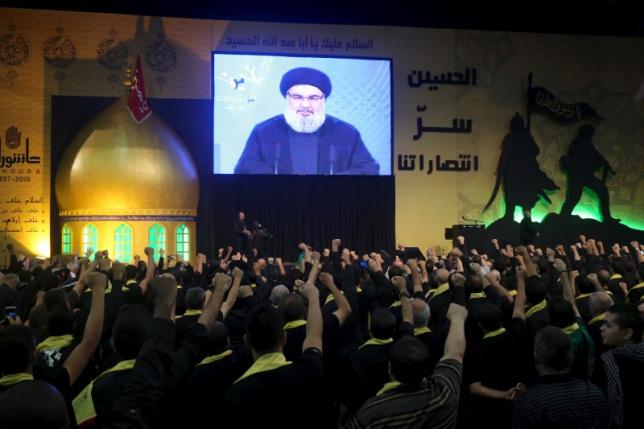 Lebanon's Hezbollah supporters gesture as they listen to their leader Sayyed Hassan Nasrallah on a screen during a religious ceremony marking the mournful Shi'ite Muslim occasion of Ashura in Beirut's southern suburbs Lebanon October 20