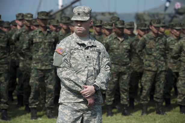 A US soldier stands in front of a line