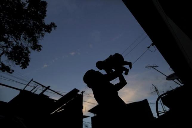 Gleyse Kelly da Silva holds her daughter Maria Giovanna who has microcephaly in front their house in Recife