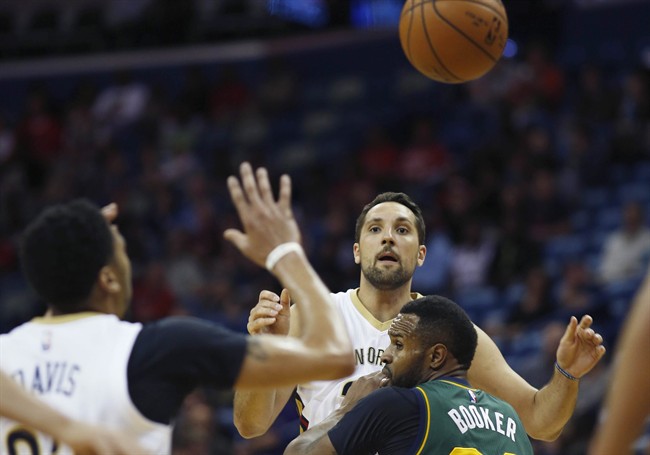 New Orleans Pelicans forward Ryan Anderson makes a pass to New Orleans Pelicans forward Anthony Davis over Utah Jazz forward Trevor Booker center in the first half of an NBA basketball game in New Orleans, La. Saturday