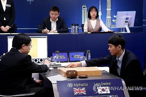 South Korean Go player Lee Se-dol places his stone against Google's artificial intelligence program Alpha Go during their fifth Go match at the Four Seasons Hotel in Seoul