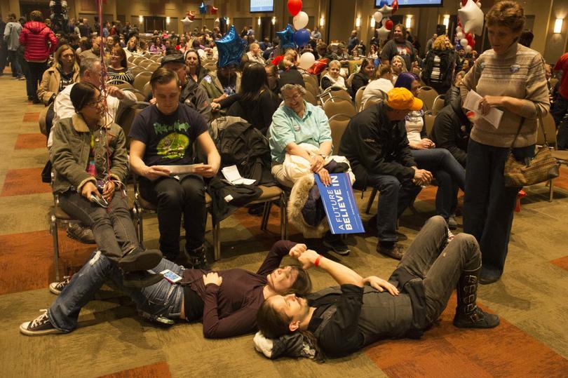 Dani Chapin of Meridian Idaho and Josh Ferryman of Boise bump fists while lying on the floor waiting for the results of the first vote at the Democratic caucus in Boise Idaho Tuesday