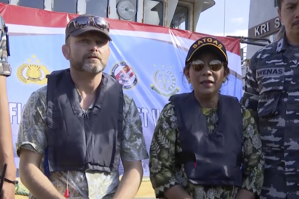 In this image made from video Stig Traavik left Norwegian Ambassador to Indonesia left and Susi Pudjiastuti Indonesia Maritime and Fisheries Minister speak before illegal fishing vessel Viking which was seized by Indonesia’s Navy is sunk with