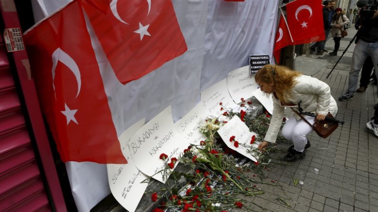 A woman places carnations at the scene of a suicide bombing at Istiklal street a major shopping and tourist district in central Istanbul Turkey