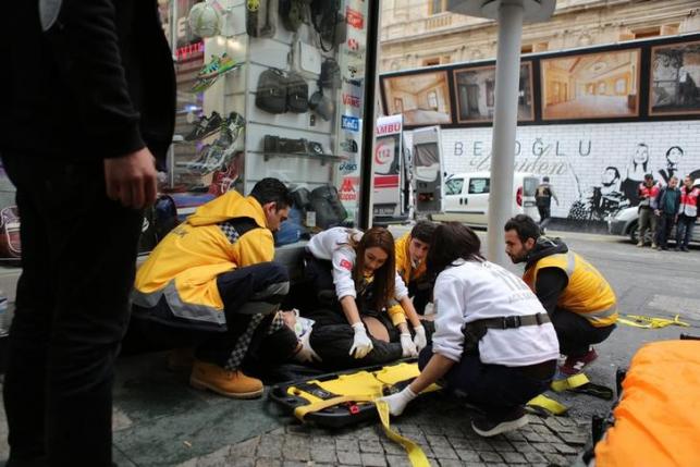 A man is helped by emergency services members following a suicide bombing in a major shopping and tourist district in central Istanbul