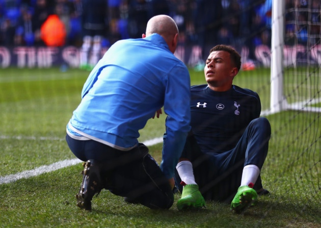 Dele Alli receives treatment after hurting his ankle in the warm-up before Sunday