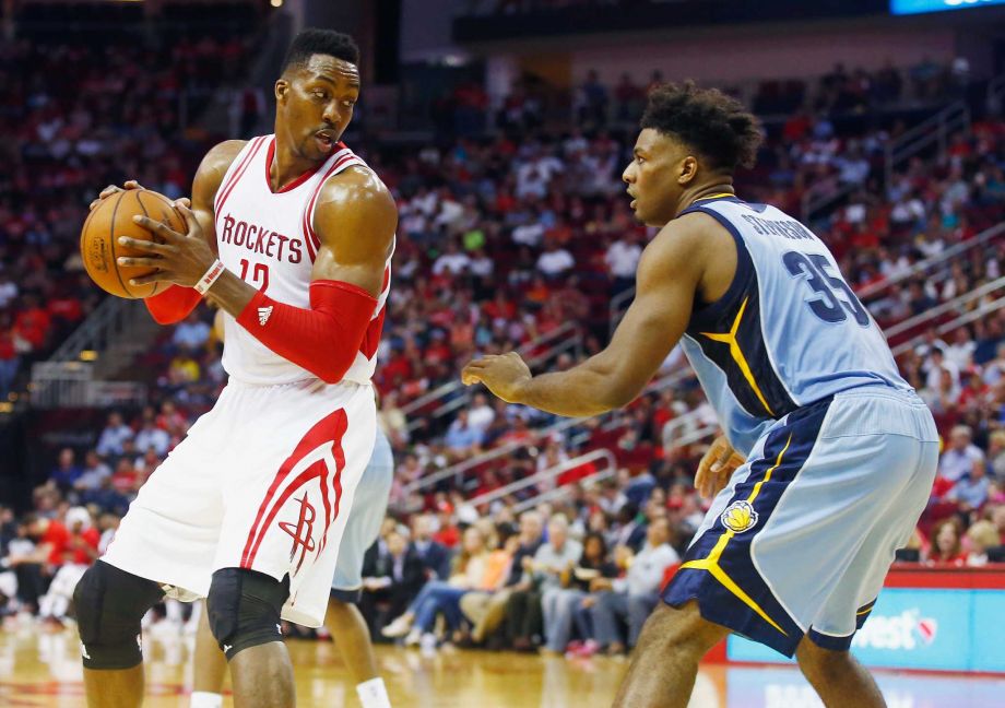 HOUSTON TX- MARCH 14 Dwight Howard #12 of the Houston Rockets looks to drive with the basketball against Alex Stepheson #35 of the Memphis Grizzlies during their game at the Toyota Center