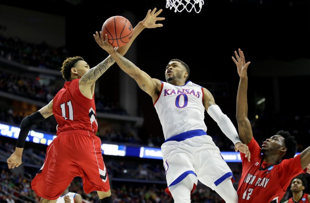 Kansas guard Frank Mason III drives to the basket between Austin Peay defenders Khalil Davis left and Kenny Jones right during the first half of a first-round men's college basketball game in the NCAA Tournament March 17