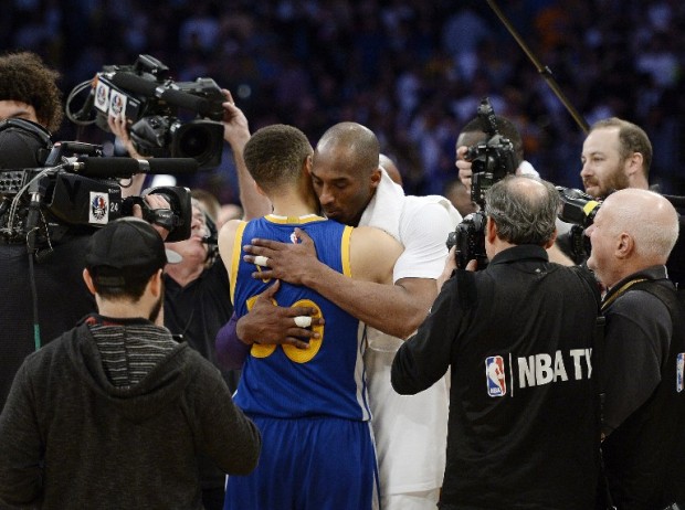 Kobe Bryant #24 of the Los Angeles Lakers hugs Stephen Curry #30 of the Golden State Warriors at the end of the basketball game at Staples Center