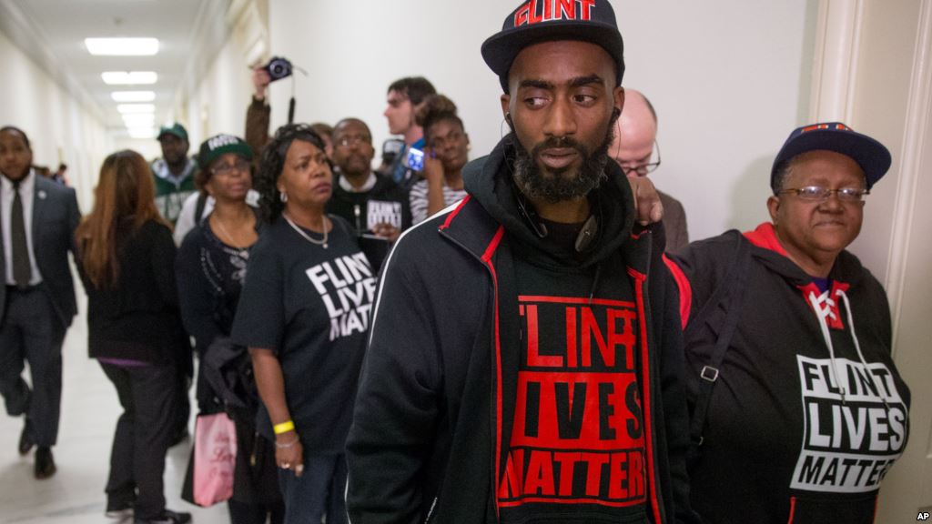 Flint residents and supporters wear shirts that reads'Flint Lives Matter as they wait outside the room where Michigan Gov. Rick Snyder and EPA Administrator Gina Mc Carthy testify before a House Oversight and Government Reform Committee hearing in Washin