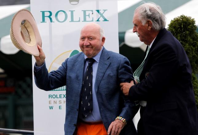 Tennis Hall of Fame member Bud Collins is helped up by fellow Tennis Hall of Famer Owen Davidson as he greets the crowd gathered for the Tennis Hall of Fame Induction Ceremony in Newport Rhode Island