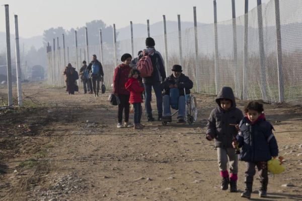 A migrant family walks towards a registration camp