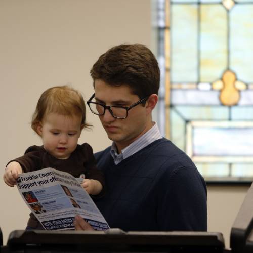 Mark Himmel holds his daughter while voting at Columbus Mennonite Fellowship Tuesday