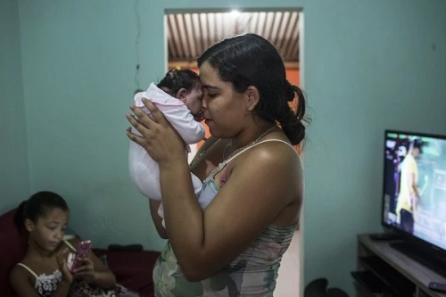 Mother holding her baby with microcephaly in Brazil