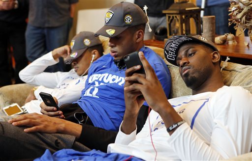 From left Kentucky's Tyler Ulis sleeps while Skal Labissiere and Alex Poythress check their phones as other members of the men's college basketball team watch the NCAA tournament selection show at the home of head coach John Ca