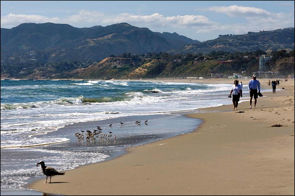 People walk along Santa Monica Beach