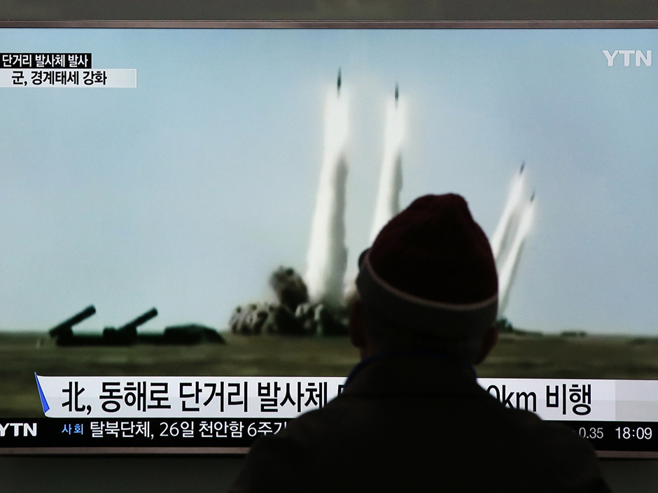 A man watches a TV screen showing a file footage of the missile launch conducted by North Korea on Monday